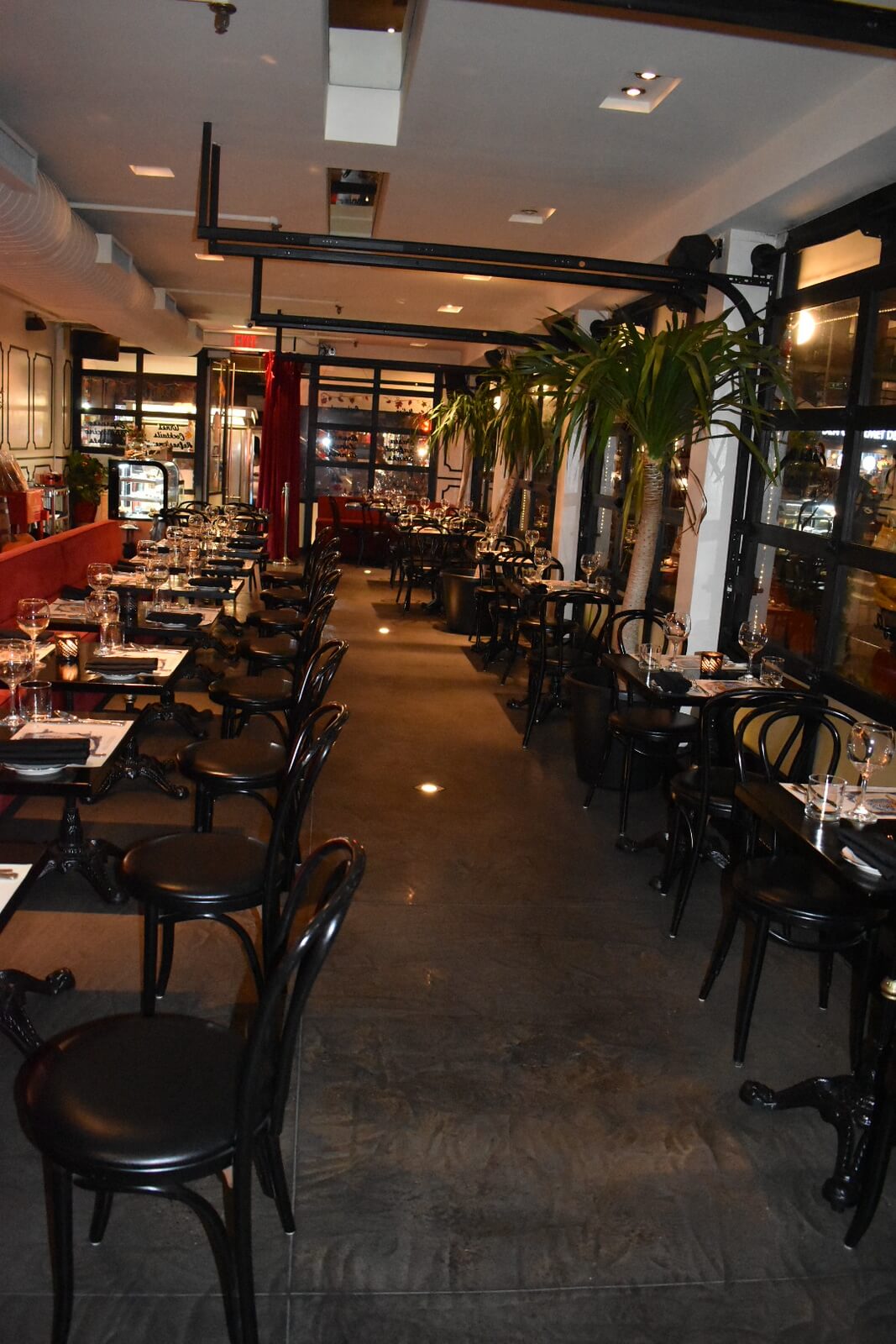 Restaurant interior showing variety of seeting options as well as garage windows and indoor plants