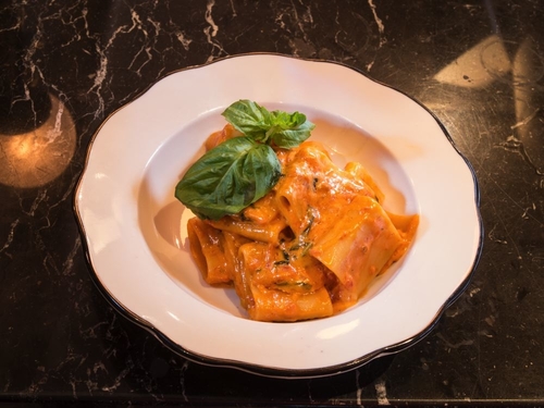 Big pasta noodles in a cream sauce and topped with basil