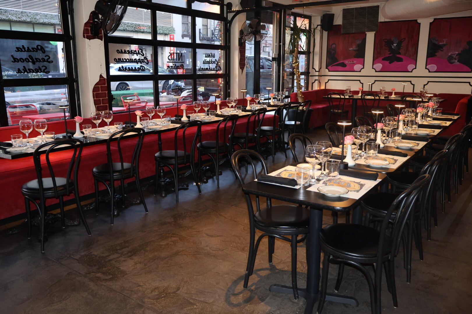 Restaurant interior showing banquet seating  as well as garage windows and indoor plants