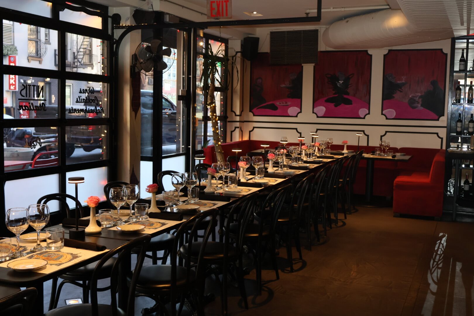 Red booths with row of tables and garage doors in background