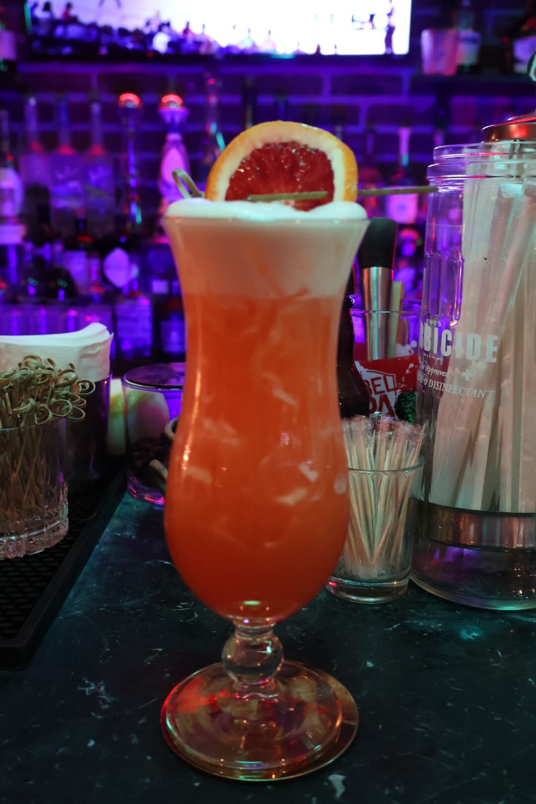 Orange cocktail in hurricane glass wth a blood orange garnish