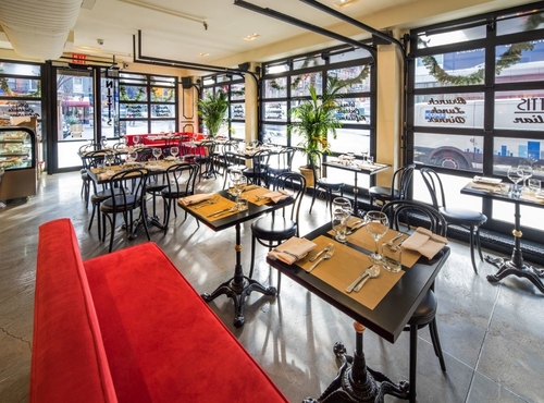 The interior of Nittis with red booths, large floor to ceiling garage windows and black table and chairs