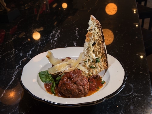 Meatball appetizer with bread, sauce, cheese and basil