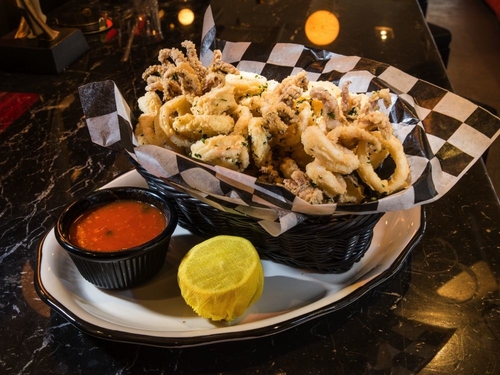 Crispy fried calamari with a side sauce and lemon