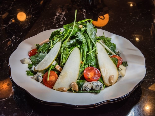 Salad with apples, nuts, tomatoes, blue cheese crubles and dressing