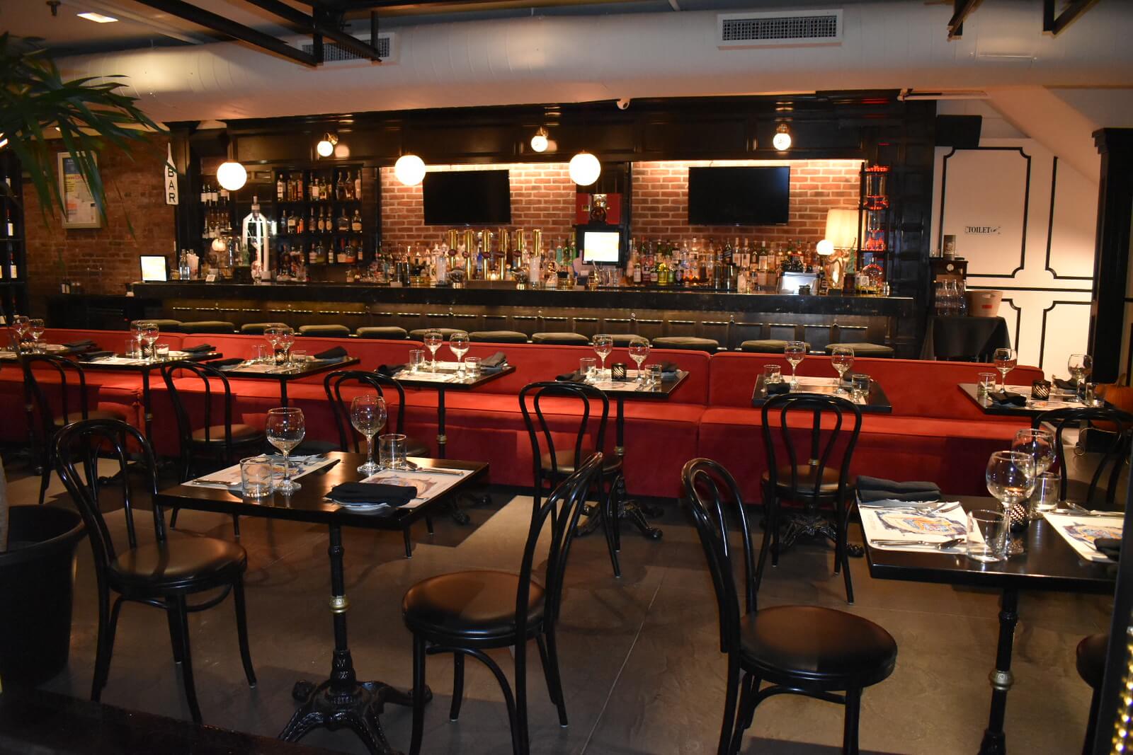 Restaurant interior showing tables, booth, and bar at night